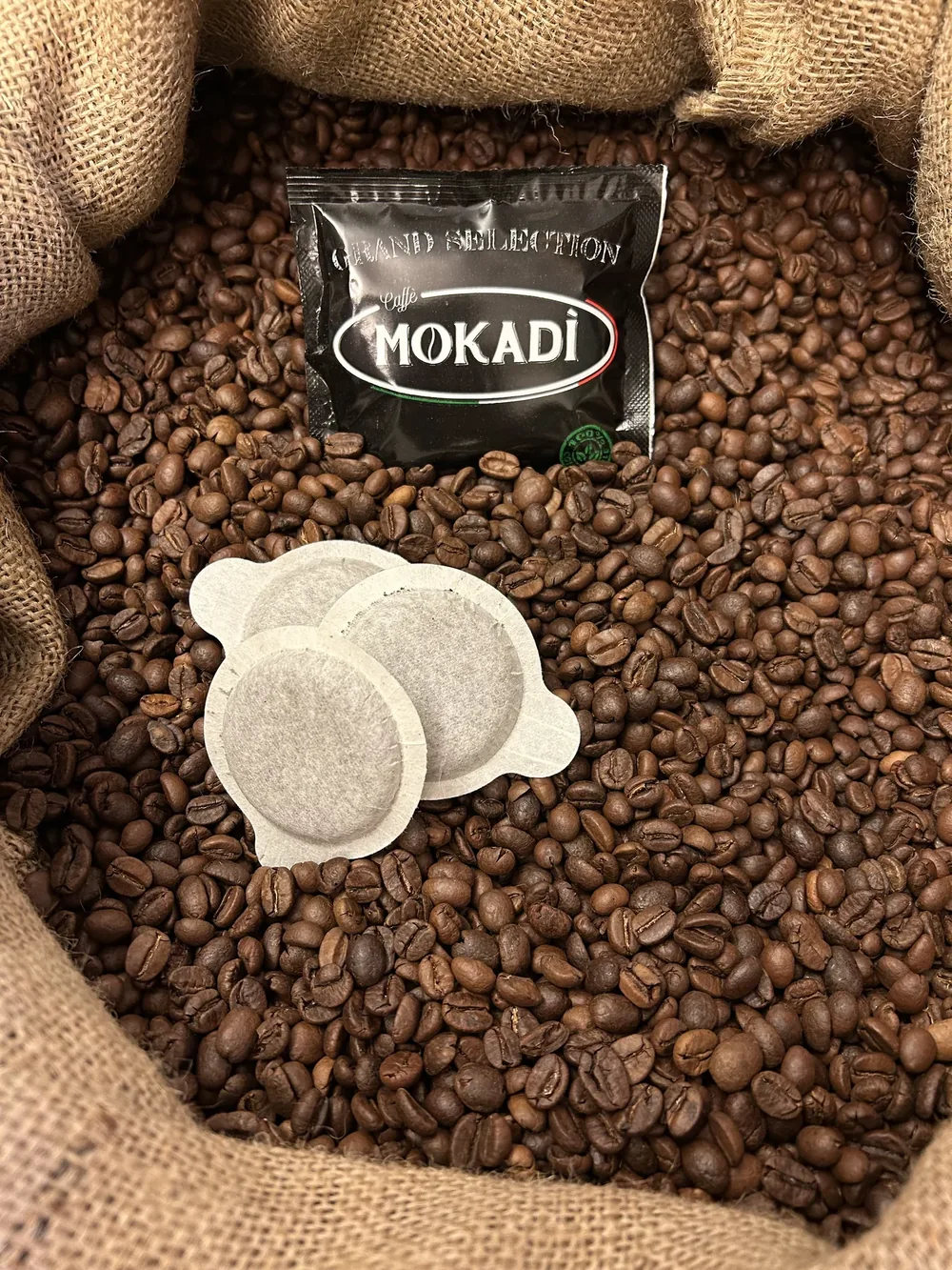 Confezione Mokadì Grand Selection e cialde su chicchi di caffè